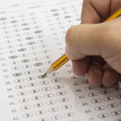 A pencil sitting on a test bubble sheet and alarm clock, optical form of an examination,Answer sheet with pencil,Standardized test form with answers bubbled and a black pencil,selective focus,vintage © Have a nice day 
