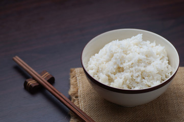 Thai rice with chopsticks on wood background