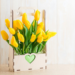 Yellow tulips in a wooden pot