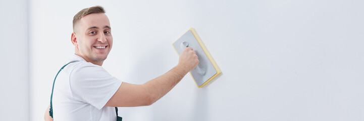 Builder with trowel plastering wall