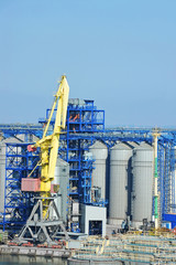 Fototapeta na wymiar Cargo crane and grain dryer