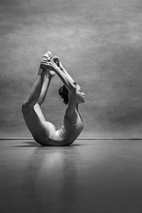 The female ballet dancer posing over gray background