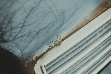 Dark car hood with rust and corrosion. Macro shot.