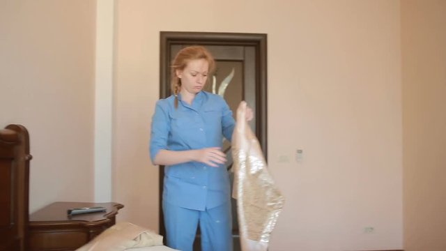 Maid doing cleaning in the bedroom
