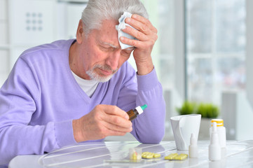 Sick elderly man taking medicine