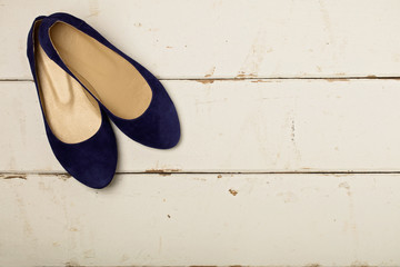Blue women's shoes (ballerinas) on wooden background.