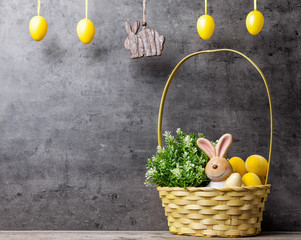 Easter holiday basket with a bunny, eggs and flowers