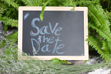 "Save the date" word written on blackboard, wedding concept