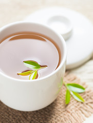 Cup of tea and tea leaves on wooden