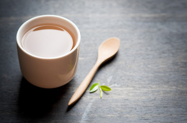 Cup of tea and tea leaves on dark wooden