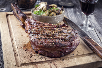 Barbecue aged Tomahawk Steak as close-up on Cutting Board