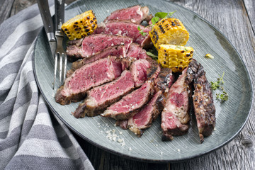 Barbecue aged Rib Eye Steak sliced as close-up on a Plate
