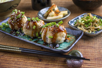 Traditional Japanese Takoyaki with Sprouts and Daikon as close-up on a plate