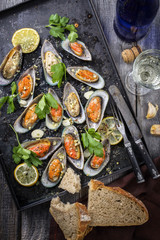 Backed Green Shell Mussels on an old rustic sheet with White Wine and Bread