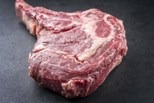 Raw dry aged Kobe Tomahawk Steak as close-up on a slate