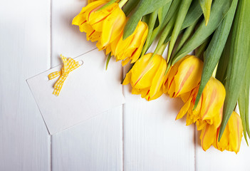 Beautiful yellow tulips and blank pape card