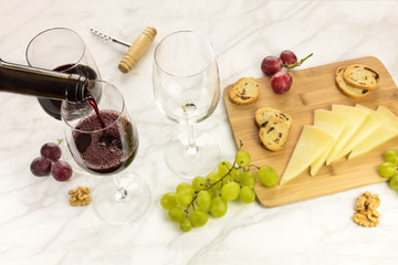 Red wine, cheese, bread and grapes at tasting