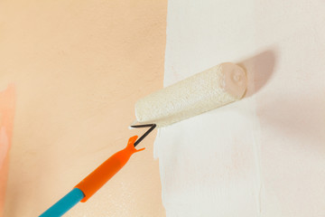 Painter painting the walls white in house