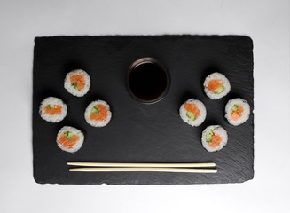 Sushi of norimaki with trout and cucumber on slate plate