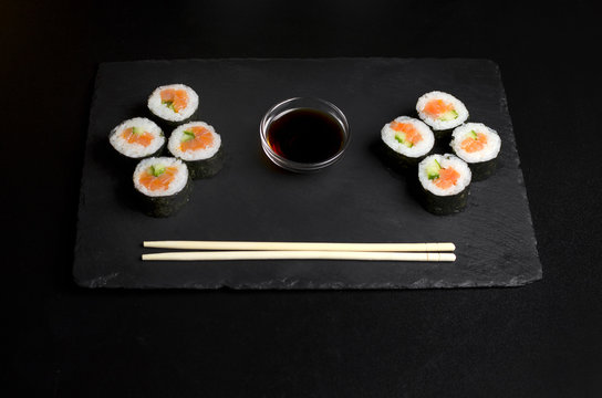 Sushi of norimaki with trout and cucumber on slate plate