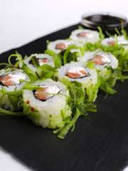 Green sushi on slate plate with bamboo sticks