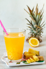 Pineapple,lemon and ginger juice in glassware on wooden table