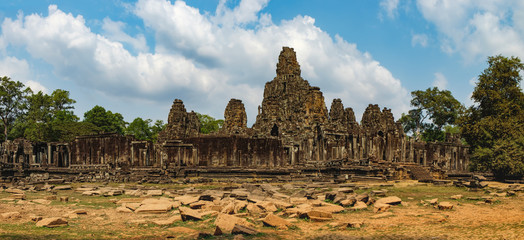 Fototapeta premium Prasat Bayon with smiling stone faces is the central temple of Angkor Thom Complex, Siem Reap, Cambodia. Ancient Khmer architecture and famous Cambodian landmark, World Heritage.
