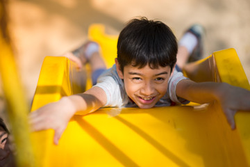 Little boy playing slider at playground