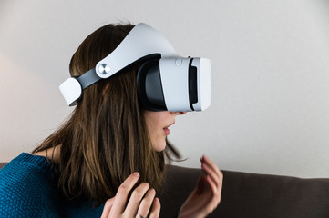 Excited girl in virtual reality headset. Young female person using vr glasses and showing emotions of interest and surprise