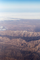Fototapeta na wymiar Clouds mountains and sky as seen through window of an aircraft of uzbekistan