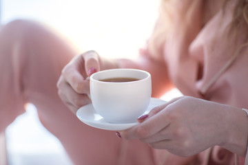 Girl holding a cup of coffee or tea