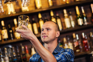Barman at work in pub,Portrait of cheerful barman worker standing,Waiter giving menus,A pub.Bar.Restaurant.Classic.Evening.European restaurant.European bar.American restaurant.American bar.