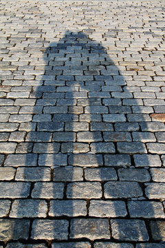 Shadows of a loving kissing couple in the city center on the cobblestones on a sunny day.