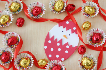 season decoration: easter chocolate eggs frame with hand made hatched chicken in eggshell on wood background with copy space