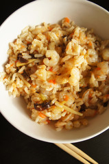 Rice with shrimps and vegetables in white bowl