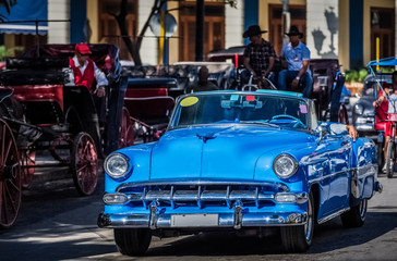 Amerikanischer blauer Cabriolet Oldtimer fährt durch Havanna Kuba - Serie Kuba Reportage