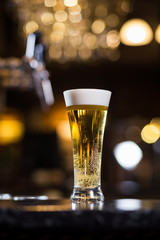 Beer, a glass of fresh cold beer on the bar.A pub.Bar.Restaurant.Classic.Evening.European restaurant.European bar.American restaurant.American bar.strong drink