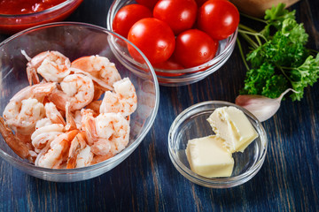 Ingredients ready for preparing pappardelle pasta with shrimp, tomatoes and herbs