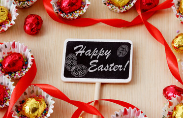 season decoration, greeting card: blackboard with inscription happy easter in chocolate eggs frame,...