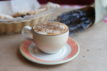 A bouquet of lavender in a craft and a cup of coffee