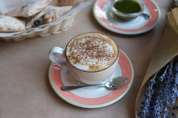 A bouquet of lavender in a craft and a cup of coffee