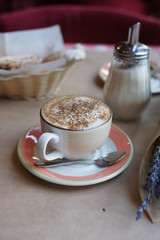 A bouquet of lavender in a craft and a cup of coffee
