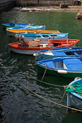 Colorful fishing boats tied up in the Amalfi harbor.