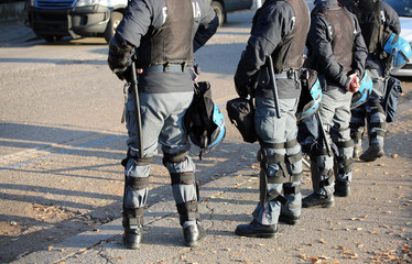 police in riot gear with flak jackets and protective helmets and
