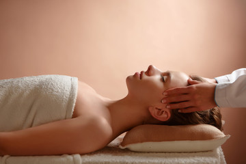 Girl massage therapist doing head massage beautiful brunette girl