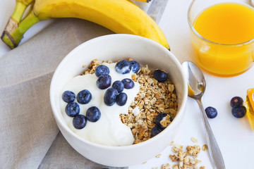 Granola bowl with yogurt and blueberries, healthy breakfast