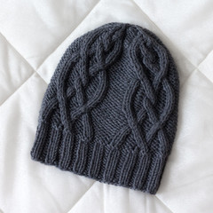 Hat black rag background knitted wool by hand on the spokes