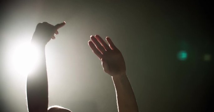 Ballerina dancing on stage, close-up of only hands with magic light on background
