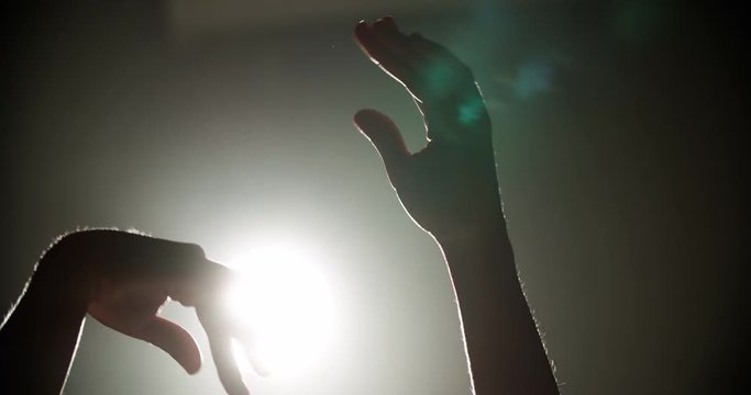 Ballerina dancing on stage, close-up of only hands with magic light on background