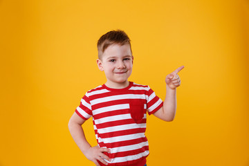 Smiling happy boy pointing finger up at copyspace © Drobot Dean